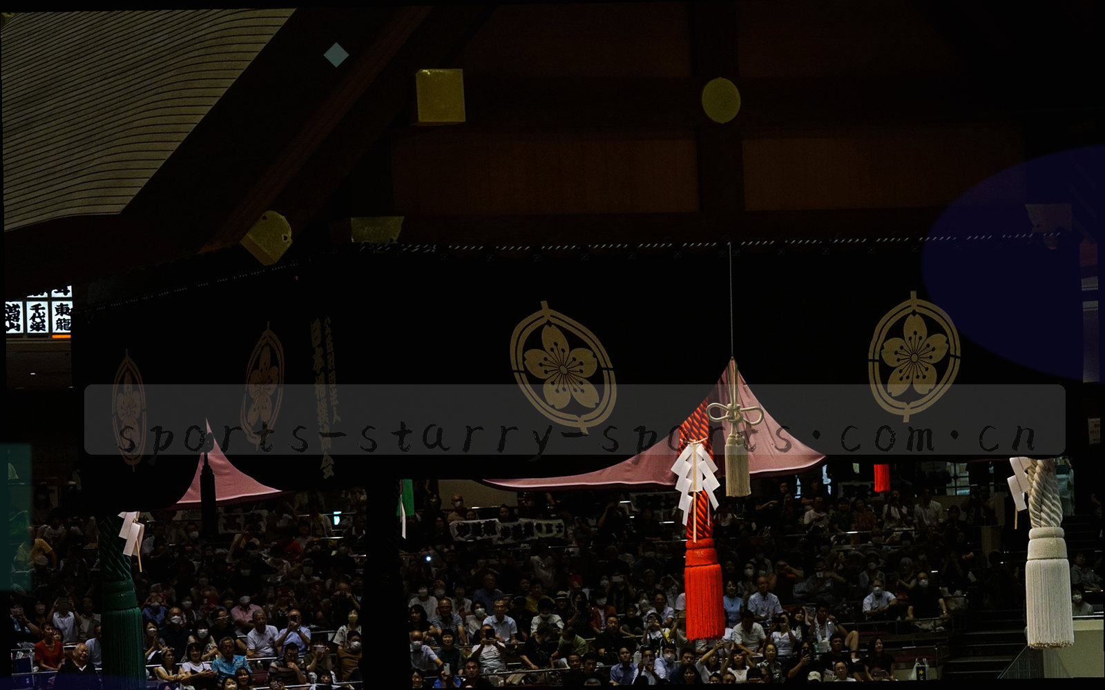 夜色中的城市天际线与远处球场灯光的抽象剪影，冷调处理，画面上方留出大片深色空白